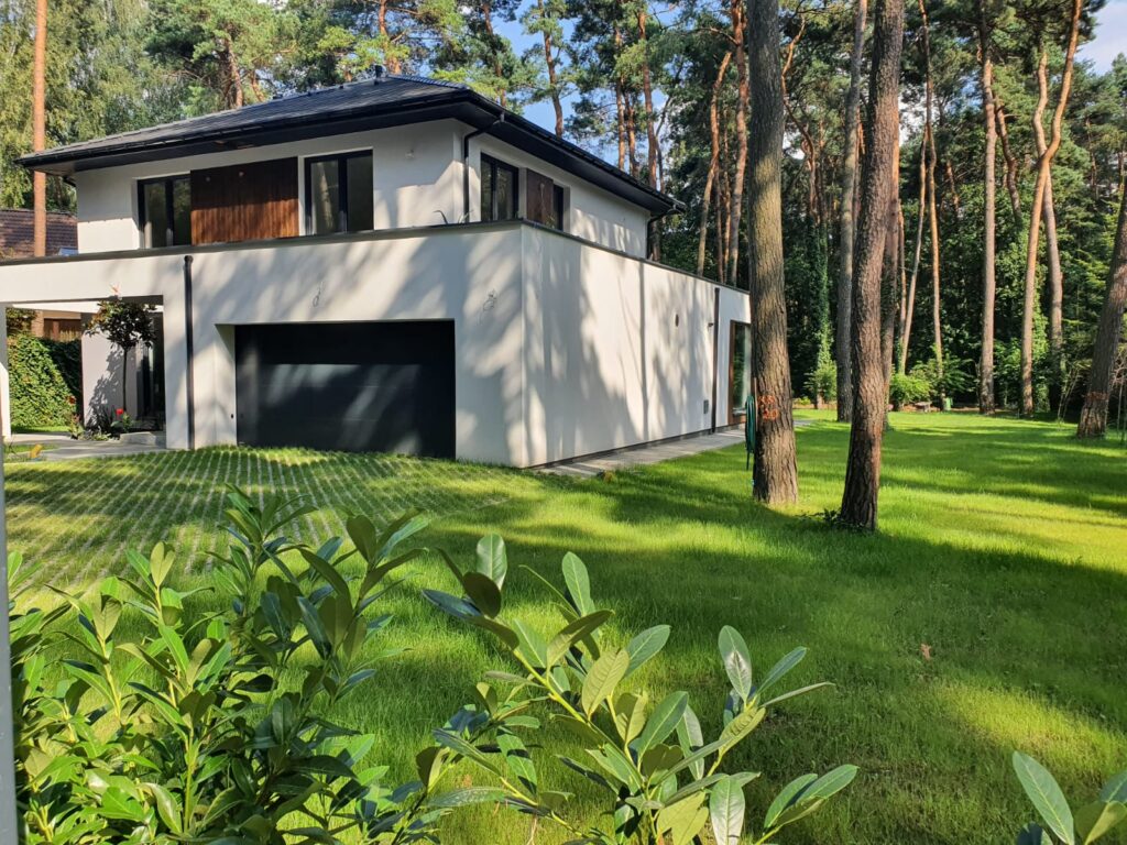Casa de dos plantas de bajo consumo energético con tejado envolvente y garaje